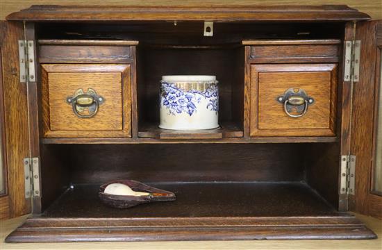 An oak smokers cabinet with a cased meerschaum pipe